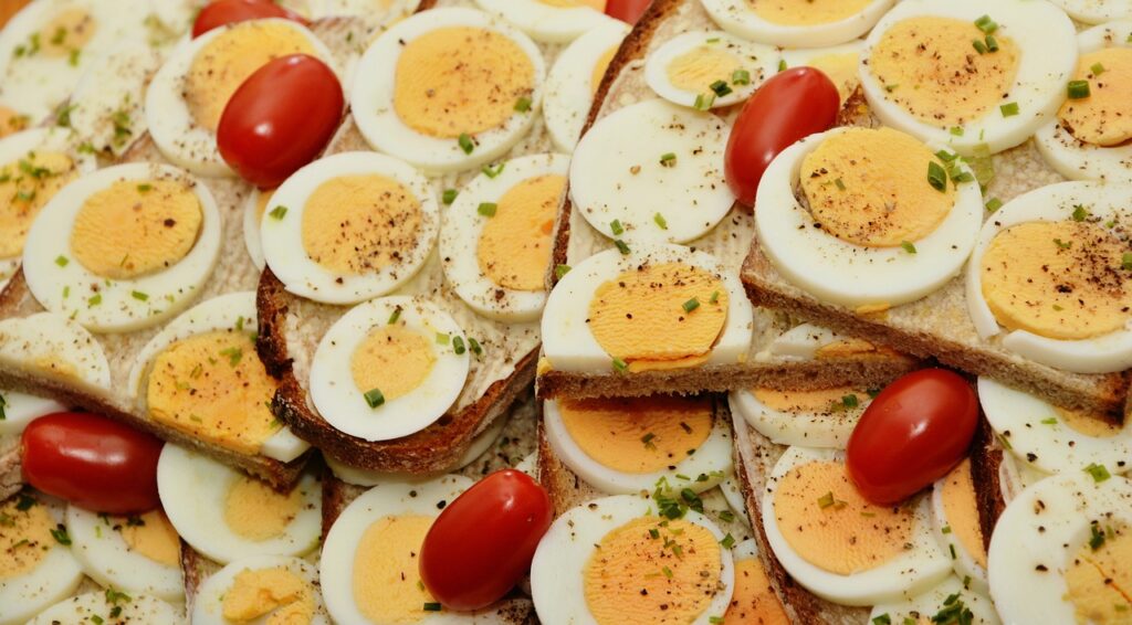 Bread with eggs, cherry tomatoes garnished with pepper flakes, and spring onions