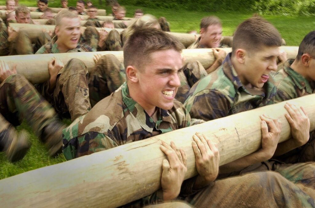 A US Army man lifting a heavy log